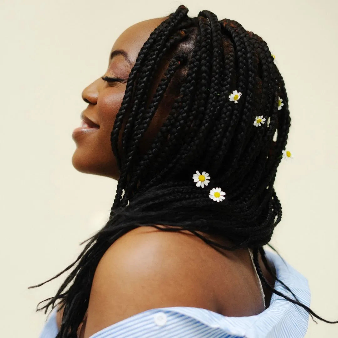 Une femme porte des mèches végétales noires de profil